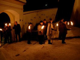 Menschen mit Fackeln auf dem Weg zur Christmette